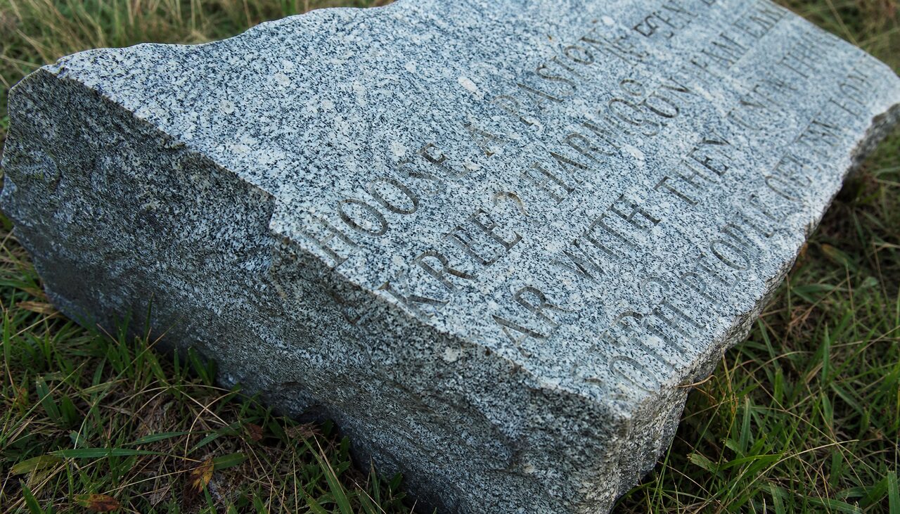 A fragment of Pyramid Blue granite in the grass, inscription still legible. Resistant to weathering. Less so to everything else.