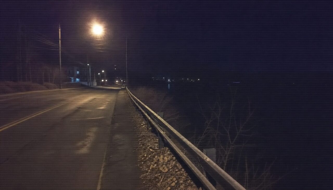 Riverside Drive, westbound: a low guardrail, the unseen river beyond it, and a curve gentle enough to take without thinking.