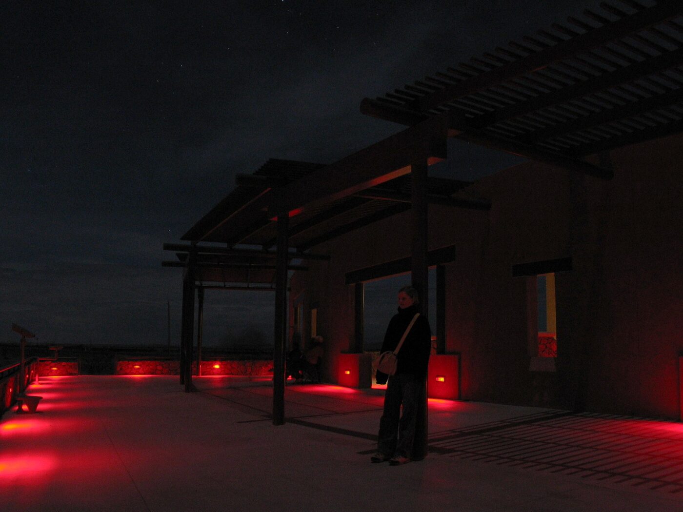 The official Marfa Lights Viewing Center, lit red on the highway east of town. One writer called it a very nice adobe restroom with binoculars bolted to the front. (photo: Daniel Schwen, CC BY-SA 2.5)