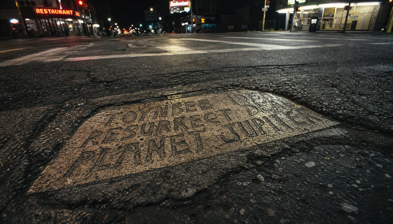 The standard tile: license-plate sized, sealed into the road, addressed to no one in particular.